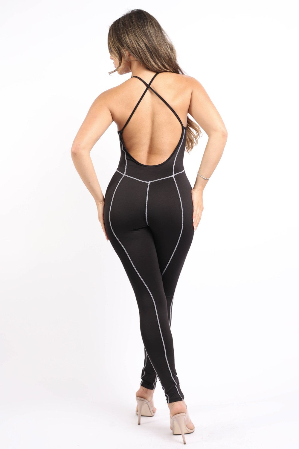Women's black overlock jumpsuit with white lines, spaghetti straps and an open criss cross back design. rear view